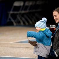 An alum smiles with her son at the tailgate